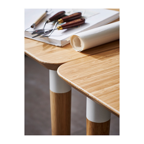 Escritorio moderno de madera con tapa de bambú claro, patas y conectores blancos; Diseñado para un fácil montaje. Herramientas en la parte superior.