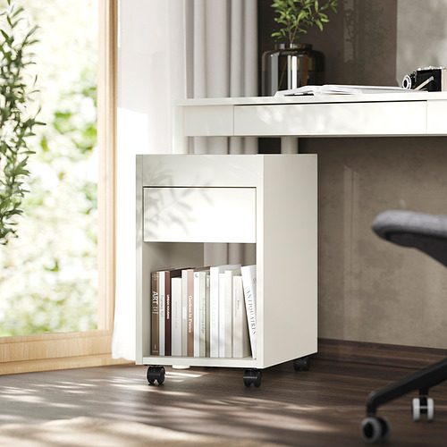 Pequeño mueble de almacenaje blanco con cajón, estantería, libros, escritorio, ventana.