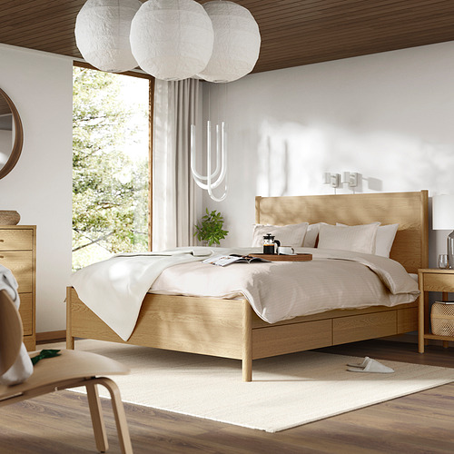 Dormitorio moderno con cama TONSTAD, lámparas colgantes, luz natural y decoración minimalista.