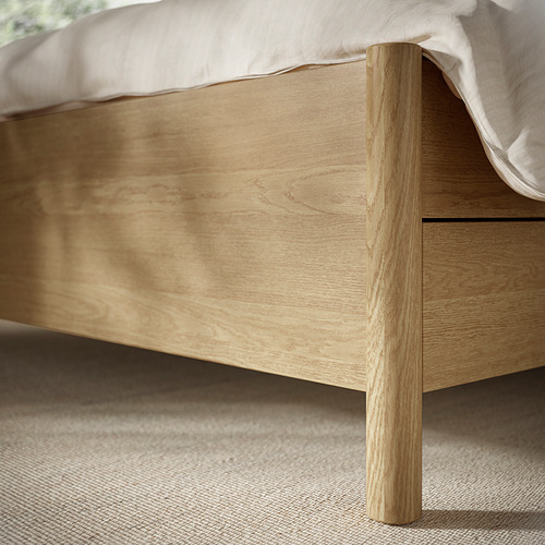 Estructura de cama de madera moderna con acabado de color claro, lados de cama ajustables y cajones de cierre suave.