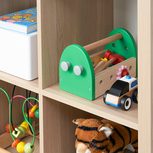 Una caja de herramientas de juguete de madera en un estante, que contiene herramientas y ruedas de colores, diseñada para el juego imaginativo y el desarrollo de habilidades motoras de los niños.