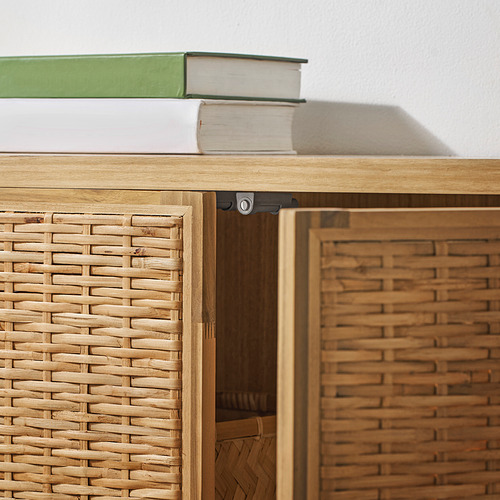 Mueble cerrado de madera con puertas de ratán trenzado, con bisagras robustas y acabado natural.
