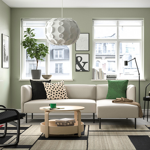 Sala de estar moderna con sofá beige LILLEHEM, paredes de salvia y vista a la ciudad.