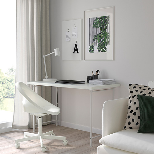 Oficina en casa minimalista: LAGKAPTEN escritorio, silla, lámpara, ordenador portátil, bloc de notas, portalápices, arte, sofá blanco con cojines.