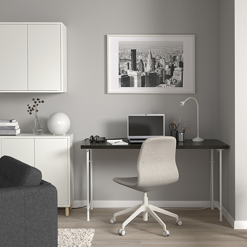 Moderno espacio de oficina en casa con escritorio lagkpten negro, silla gris y decoración elegante.