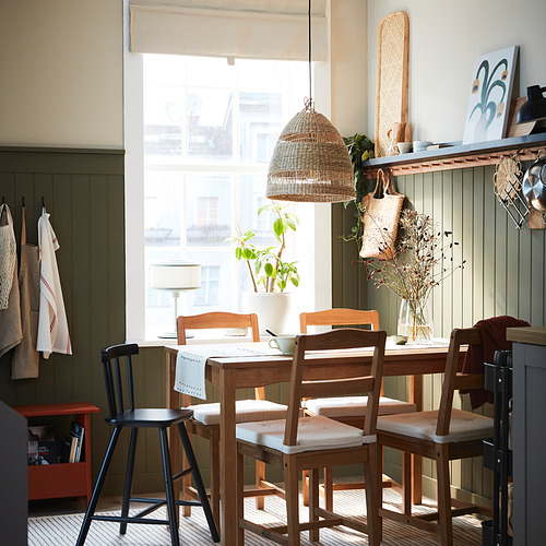 Cocina amplia y luminosa con mesa de madera, sillas y lámpara colgante colgante. Gran ventanal deja entrar la luz natural.