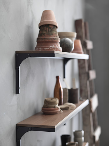 Estantería de pared rústica de estilo industrial con soportes metálicos, que sostiene una variedad de macetas y jarrones de terracota.