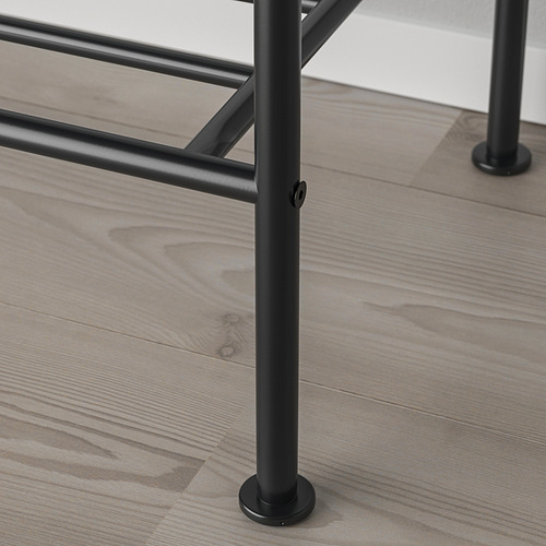Primer plano de una robusta pata de mesa de metal sobre un suelo de madera, que muestra el diseño industrial y la calidad de la construcción.