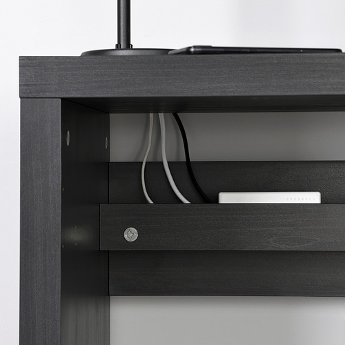 Escritorio negro con sistema de gestión de cables, cables visibles a través de la parte trasera abierta. Escritorio diseñado para un espacio de trabajo organizado y ordenado.