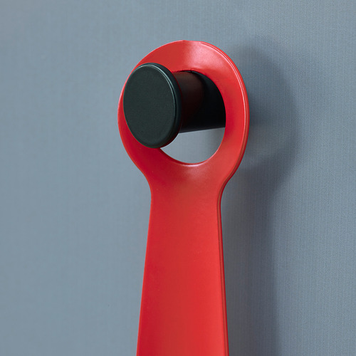 El calzador de metal rojo cuelga cuidadosamente en el gancho de la pared. Diseño brillante y compacto para facilitar su uso y almacenamiento.