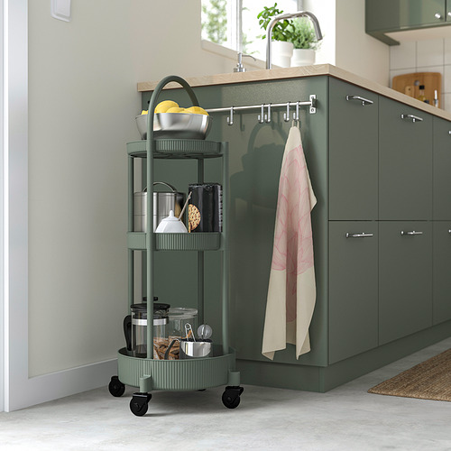 El moderno carro JUTTERSBO de color verde grisáceo con 3 estantes almacena elementos esenciales de cocina, cabe perfectamente junto a los armarios.