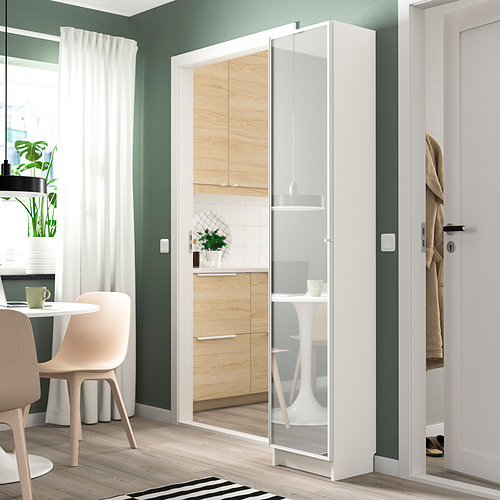 Apartamento moderno con estantería blanca BILLY, comedor y paredes verdes apagadas.