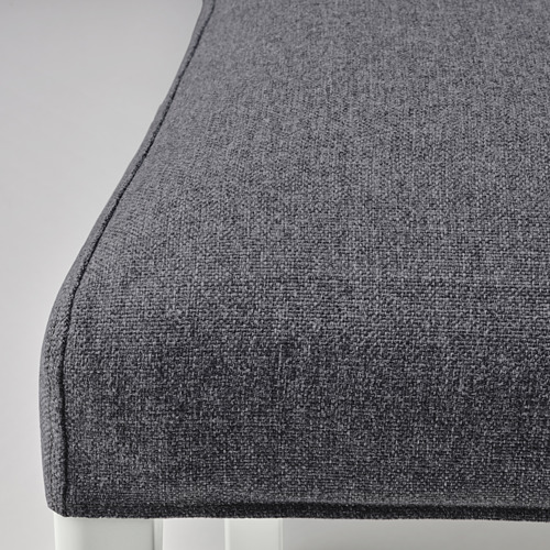 Primer plano de tela gris acolchada en una silla moderna, que muestra textura y material de calidad.