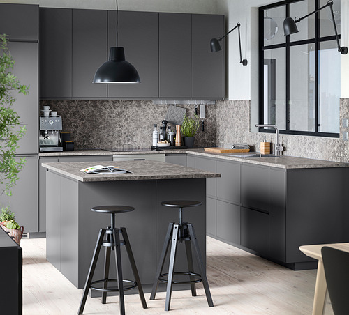 Cocina minimalista con armarios METOD grises, encimera de mármol, lámpara colgante negra y taburetes de bar.