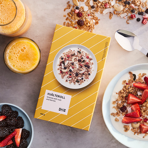 Caja de granola HJÄLTEROLL de Ikea con frutos secos y frutos rojos. La caja abierta muestra una mezcla de granola lista para comer con yogur y frutas.