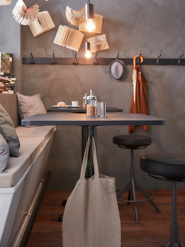Moderna mesa de comedor cuadrada con una elegante base de metal negro y tablero gris. Dos ganchos debajo. Perfecto para espacios pequeños.