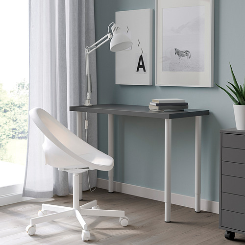 Moderna oficina en casa con escritorio LINNMON negro, silla blanca ajustable, lámpara, obras de arte de cebra y una planta.