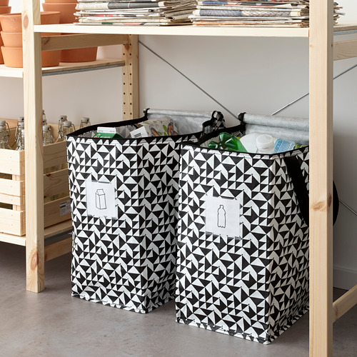 Bolsa KNALLA con materiales reciclables, debajo de estante de madera.