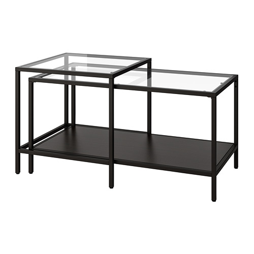 Mesas nido negras, tapas y estante inferior de cristal, estructura metálica, diseño minimalista.