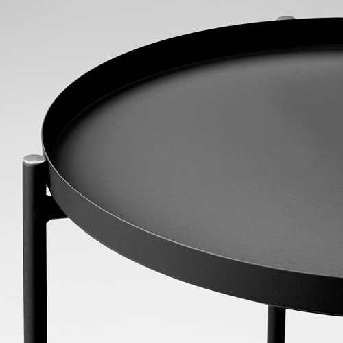 Moderna mesa redonda con bandeja con elegante acabado negro. Superficie duradera de acero con recubrimiento en polvo, soportada por robustas patas metálicas.