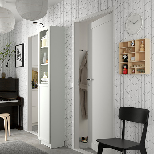 Pasillo moderno con estantería blanca BILLY, silla negra, reloj de pared, papel pintado geométrico, piano negro y lámparas colgantes.