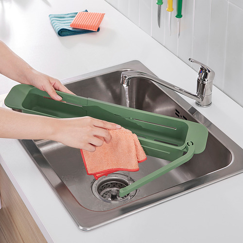 Organizador de fregadero skola verde con paño, paño de cocina y desagüe de fregadero metálico.