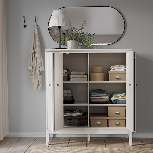 Organized storage cabinet IDANÄS with folded doors, white, holding clothes, boxes, and books. Stylish and functional.