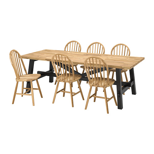 Juego de comedor SKOGSTA con mesa rectangular de madera de acacia y seis sillas con respaldo de huso.