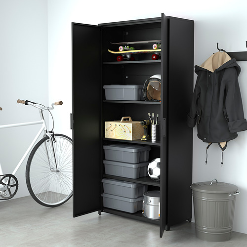 El gabinete de almacenamiento negro en el garaje contiene contenedores grises, equipo deportivo y herramientas. Bicicleta y chaquetas cerca.