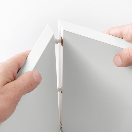 Las manos ensamblan la unidad de pared EKET, mostrando su diseño modular para una fácil configuración.