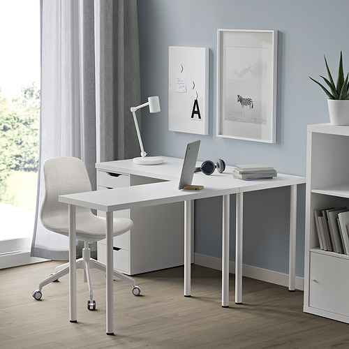 Oficina en casa con escritorio LINNMON blanco, computadora portátil, silla y decoraciones. Compacto pero espacioso, se coloca debajo del arte de la pared y al lado de las estanterías.