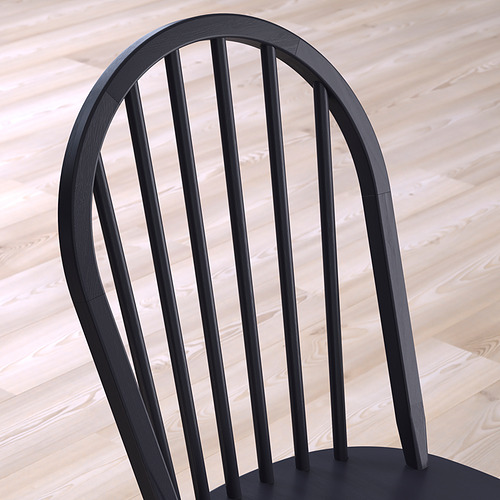 Silla de madera negra con respaldo arqueado y husos, que muestra una artesanía robusta.