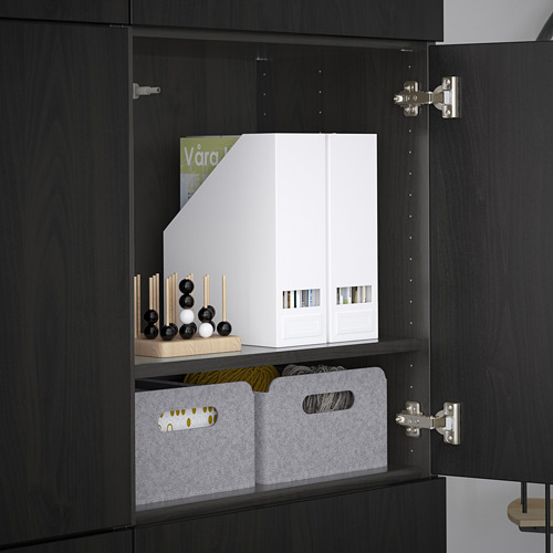 Mueble negro con estantes ajustables. Las cajas blancas y los contenedores grises almacenan los artículos de forma ordenada. Bisagras visibles, indicando puertas ajustables.
