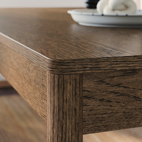 Mesa de comedor de madera oscura con bordes lisos y redondeados, que muestra una artesanía de alta calidad y un acabado mate cepillado.