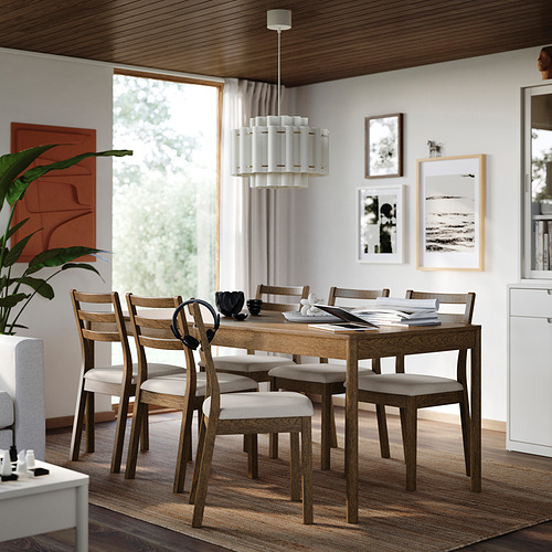 Mesa de comedor de roble TONSTAD con 6 sillas a juego, colocada en el centro, bien iluminada y acogedora, con una decoración elegante.