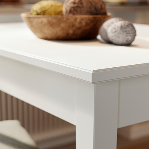 Mnml. -score: mesa blanca con bordes elegantes, patas de madera estables. Un tazón de fruta se encuentra encima.