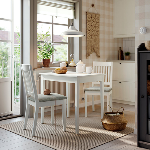 Acogedora cocina con mesa y sillas NÄSINGE, perfecta para espacios pequeños.