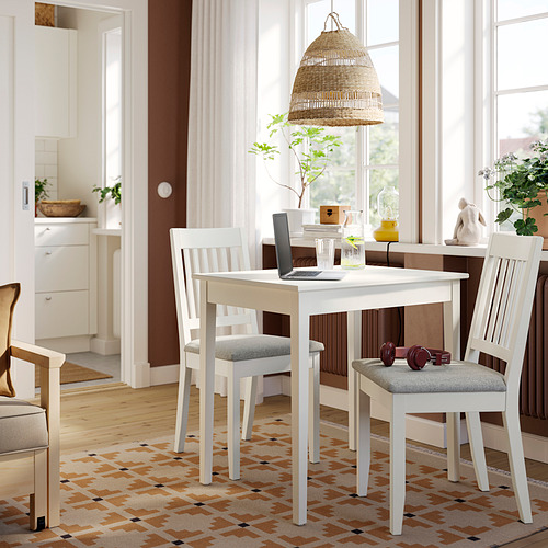 Mesa de comedor y sillas blancas compactas NÄSINGE colocadas en una habitación luminosa.