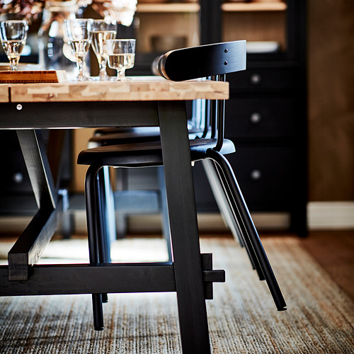 Silla moderna de metal negro con asiento de madera, perfecta para espacios de comedor.