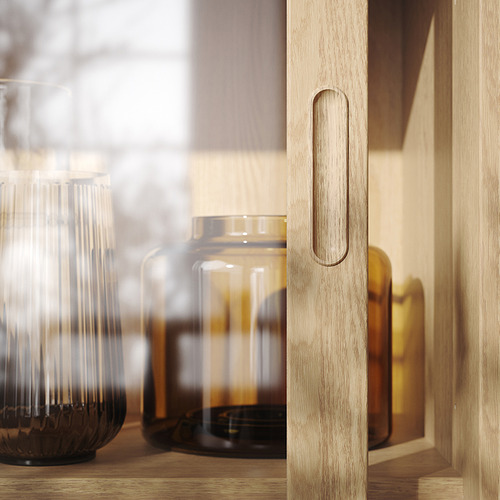 Minimalist wooden cabinet with clear glass jars, soft lighting, and knurled handles.