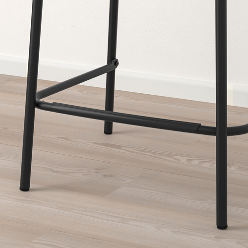 Moderno taburete de bar de metal negro sobre suelo de madera
