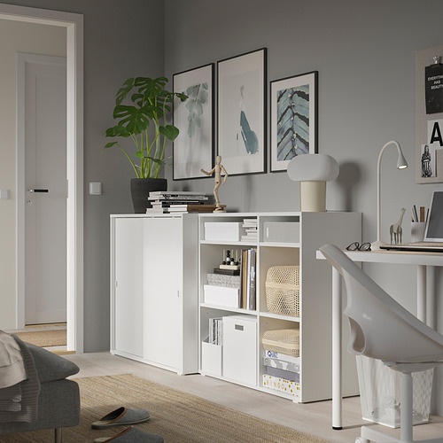 Moderna oficina en casa con unidades de almacenamiento VIHALS blancas; Incluye estantes, puertas correderas y artículos decorativos.