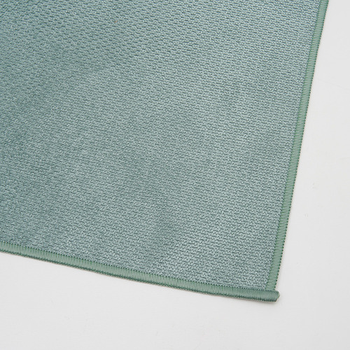 Paño de microfibra verde, limpio y cuidadosamente doblado, con una textura de calidad.