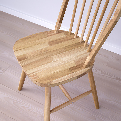 Silla de madera en primer plano. Acabado de color canela claro, asiento liso y respaldo de listones. Elaborado en madera de acacia maciza, con patrones de grano fino.