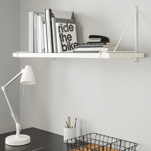 Estantería BERGSHULT con libros y grapadora. Abajo, escritorio con lámpara, portalápices y cesta de artículos de madera.