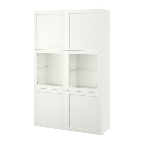 Un mueble de almacenaje BESTÅ blanco con puertas de cristal y estantes ajustables, que combina expositor y almacenamiento oculto.