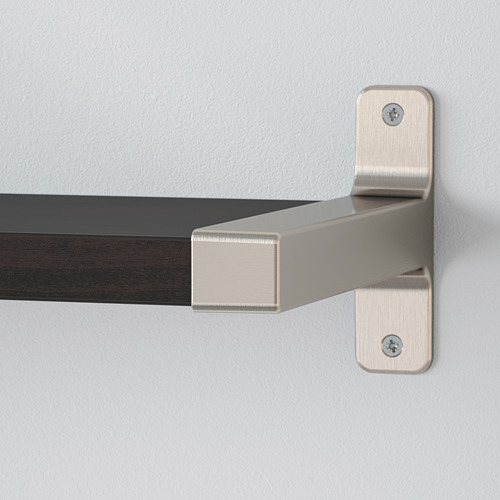 Estante de pared con soporte metálico. El estante tiene un borde biselado, bien asegurado con tornillos. Pared de color neutro en el fondo.