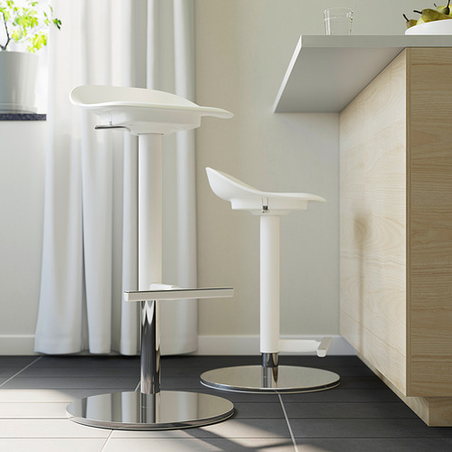 Dos modernos taburetes blancos con bases y reposapiés cromados colocados en una cocina minimalista.