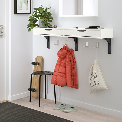 Estantería blanca EKBY ALEX con cajones, monopatín, chaqueta roja, planta y bolso.