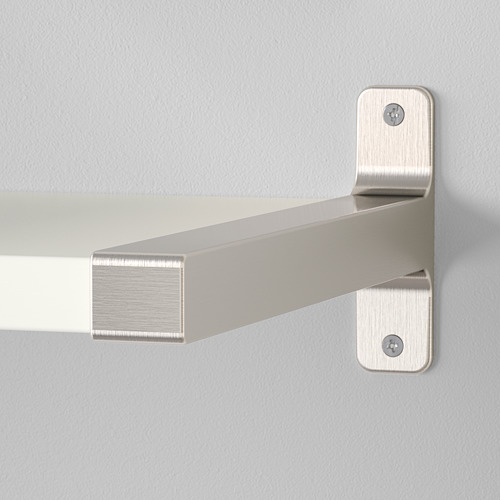 Soporte de estante de metal niquelado fijado de forma segura a una pared elegante y moderna.